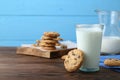 Delicious chocolate chip cookies and glass of milk on wooden table, space for text Royalty Free Stock Photo