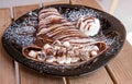 Delicious chocolate crepe with marshmallows in a brown plate Royalty Free Stock Photo