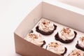 Delicious chocolate cupcakes with cream in an open gift box on a white background partial photo Royalty Free Stock Photo