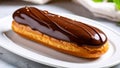 Delicious chocolate eclair pastry dessert on a white plate close-up Royalty Free Stock Photo