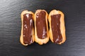 Delicious chocolate eclairs on a black table. Royalty Free Stock Photo