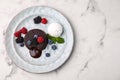 Delicious chocolate fondant served with fresh berries and ice cream on white marble table, top view. Space for text Royalty Free Stock Photo
