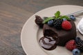 Delicious chocolate fondant served with fresh berries on wooden table, closeup. Space for text Royalty Free Stock Photo