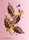 Delicious chocolate ice cream in crispy cones falling on pink Royalty Free Stock Photo