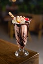 Delicious chocolate shake with chocolate icing and biscuits, marshmallows and candy inside the beautiful interior of Royalty Free Stock Photo