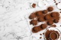 Delicious chocolate truffles with cocoa powder and hazelnuts on white marble table, flat lay. Space for text Royalty Free Stock Photo