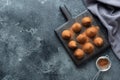 Delicious chocolate truffles sprinkled with cocoa powder and walnuts on a wooden stand. Dark concrete background. Copy space Royalty Free Stock Photo