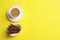Delicious chocolate wafer rolls and cup of coffee on color background, top view with space for text Royalty Free Stock Photo