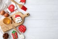 Delicious Christmas cookies and ingredients on white wooden table, flat lay with space for text Royalty Free Stock Photo