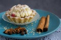 Delicious Christmas dessert.Chocolate cake with cream and raspberry jam on a blue plate next to anise and cinnamon on a white