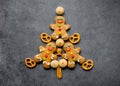 Delicious Christmas gingerbread men in the form of a Christmas tree. Christmas baking ingredients and supplies on dark background Royalty Free Stock Photo