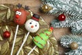 Delicious Christmas themed cake pops and fir tree branches with balls on wooden table, flat lay Royalty Free Stock Photo