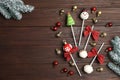 Delicious Christmas themed cake pops with fir tree branches and balls on wooden table, flat lay. Space for text Royalty Free Stock Photo