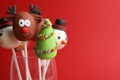 Delicious Christmas themed cake pops on red background, closeup. Space for text Royalty Free Stock Photo