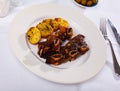 Grilled churrasco veal ribs with side dish of baked potatoes Royalty Free Stock Photo
