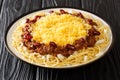 Delicious Cincinnati chili with spaghetti, cheddar cheese, fresh onions and beans close-up in a plate. horizontal Royalty Free Stock Photo