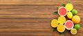 Delicious citrus fruits and green leaves on wooden background