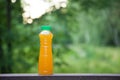 Delicious citrus juice in a plastic bottle on the background of summer nature