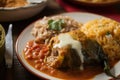 Delicious close-up of a golden-brown battered Chiles Rellenos stuffed with seasoned beef and served with rice