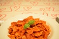 Delicious dish of an italian pasta. Bow tie noodles with tomato and basil, recipe from Rome, Italy Royalty Free Stock Photo