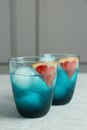 Delicious cocktails with grapefruit and ice balls on grey table, space for text Royalty Free Stock Photo