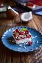 Coconut cake with raspberry layer and topped with white chocolate shavings and freeze - dried raspberries Royalty Free Stock Photo