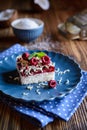 Coconut cake with raspberry layer and topped with white chocolate shavings and freeze - dried raspberries