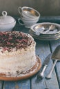 Delicious coconut layer cake - biscuit and cream on coconut cream, decorated with grated chocolate and candied rose petals