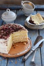 Delicious coconut layer cake - biscuit and cream on coconut cream, decorated with grated chocolate and candied rose petals