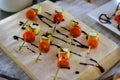 Delicious cold appetizers on skewers, close-up. Cherry tomatoes, soft cheese on a wooden plate. Banquet, catering, restaurant