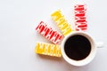 Delicious color bright cakes and coffee cup on white background, minimal concept. Royalty Free Stock Photo