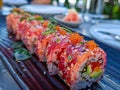 Delicious Colorful Spicy Tuna Roll Sushi with Roe and Sesame Seeds on a Black Plate, Japanese Cuisine Concept Royalty Free Stock Photo