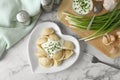 Delicious cooked dumplings sour cream on white marble table, flat lay