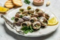 Delicious cooked sea escargo snails with herbs, butter, garlic on metal plate with forks. wine glass. gourmet food. Restaurant Royalty Free Stock Photo