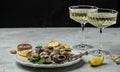 Delicious cooked sea escargo snails with herbs, butter, garlic on metal plate with forks. wine glass. gourmet food. Restaurant Royalty Free Stock Photo