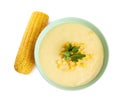 Delicious corn cream soup and cob on background, top view