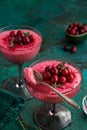 Delicious cranberry mousse dessert in glass served with fresh berry and thyme