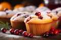 Delicious cranberry orange muffins on blurred kitchen background with copy space for text