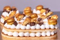 Delicious cream cake decorated with golden sweets.