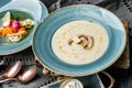 Delicious cream of mushroom soup in bowl and dumpling soup on a modern dark background, close up view. Traditional healthy food Royalty Free Stock Photo