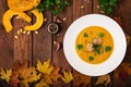 Delicious cream of pumpkin soup with meatballs made of turkey minced meat in a bowl on a wooden table. Royalty Free Stock Photo