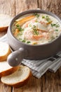 Delicious creamy fish soup with cod and salmon close-up in a bowl served with fresh bread. vertical Royalty Free Stock Photo