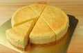 Delicious creamy yellow plain baked cheesecake with one piece cut from the whole cake