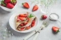 Delicious crepe with cream cheese and fresh strawberry on white