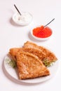 Delicious crepes with red caviar, dill and sour cream, isolated