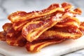 Delicious crispy bacon strips piled on white marble surface Royalty Free Stock Photo