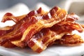 Delicious crispy bacon strips piled on white marble surface Royalty Free Stock Photo