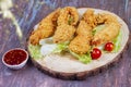 Delicious crispy fried breaded chicken breast strips with ketchup. Isolated on wooden background