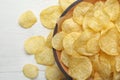 Delicious crispy potato chips in bowl on table, space for text