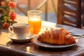 Delicious croissant and cup of coffee or tea on wooden table in cafe